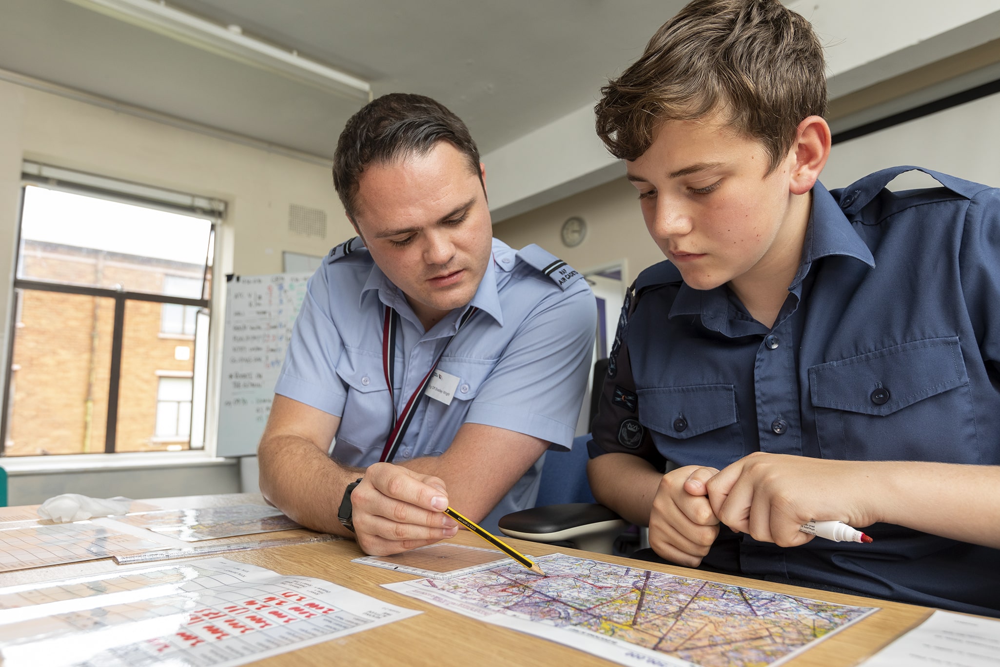 Volunteer teaching cadet about maps